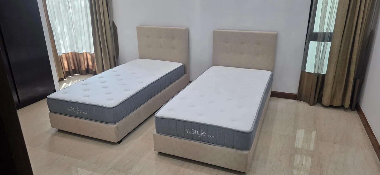 The furnished ground-floor guest room at Villa Mont Kiara, set up with two single beds.